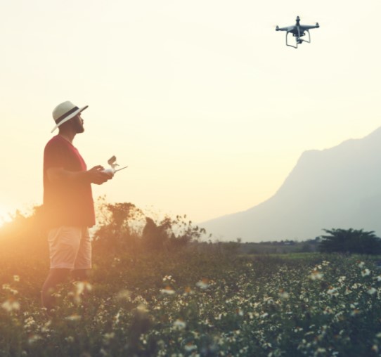 Man in field flying a drone