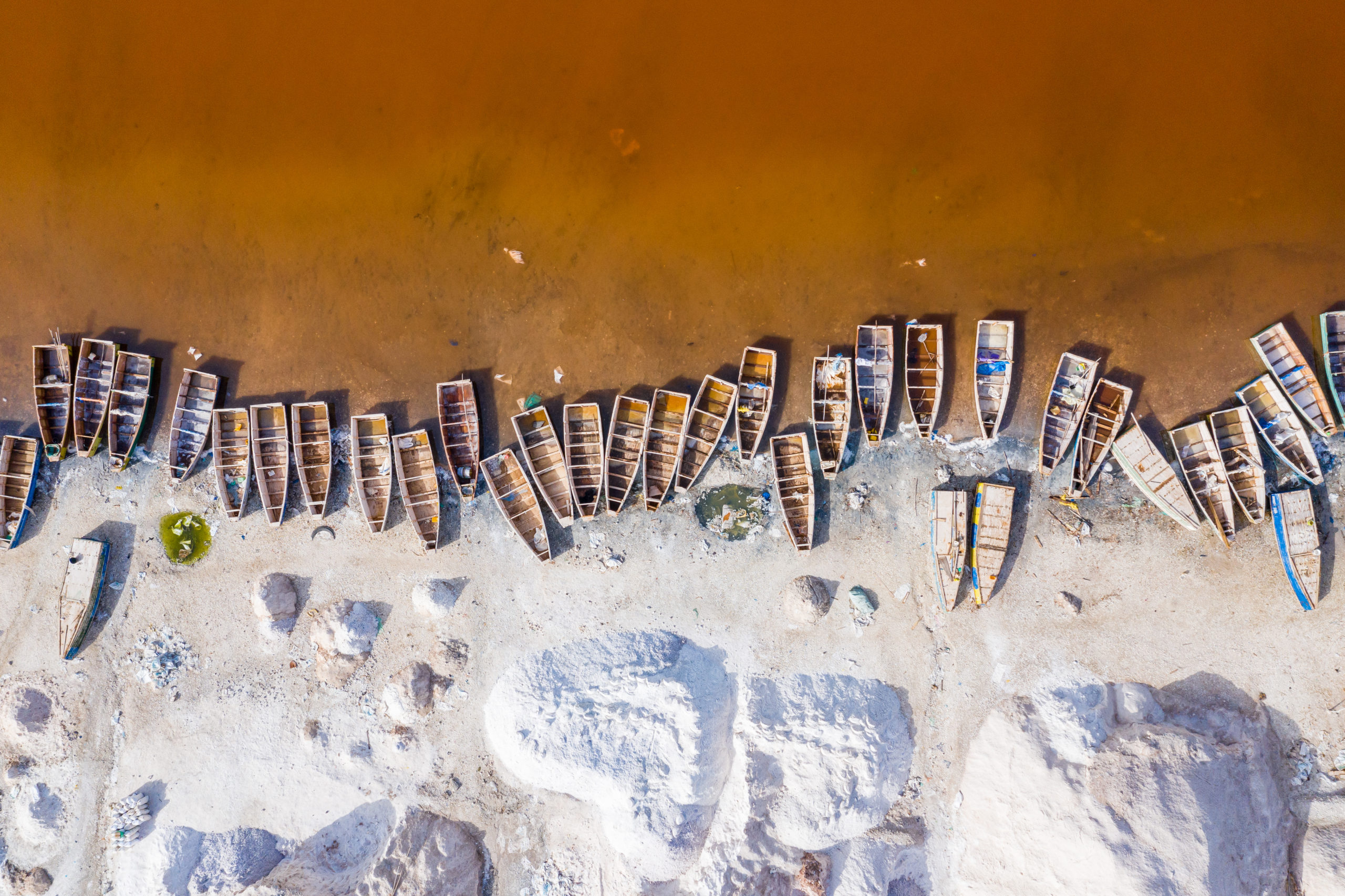 Photo of row boats beached together on a shore line