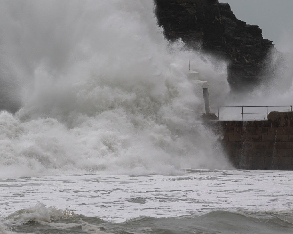 Side on view of large storm wave hitting manmade structure in Portreath Cornwall, United Kingdom