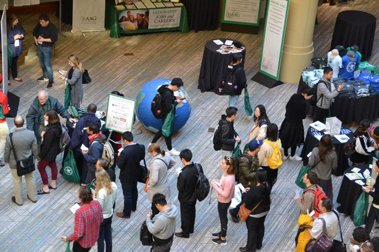 Overhead view of AAG annual meeting attendees browsing the Meridian Space information area
