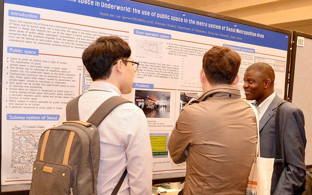 Students discuss a poster presentation on the use of public space in the metro system of Seoul during the AAG annual meeting.