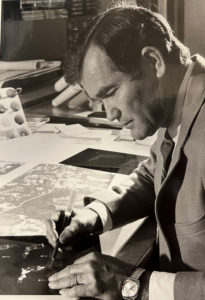 Portrait of Edward Fernald working on maps at his desk