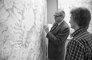 Photo of William Laatsch pointing to a large wall map with student looking on