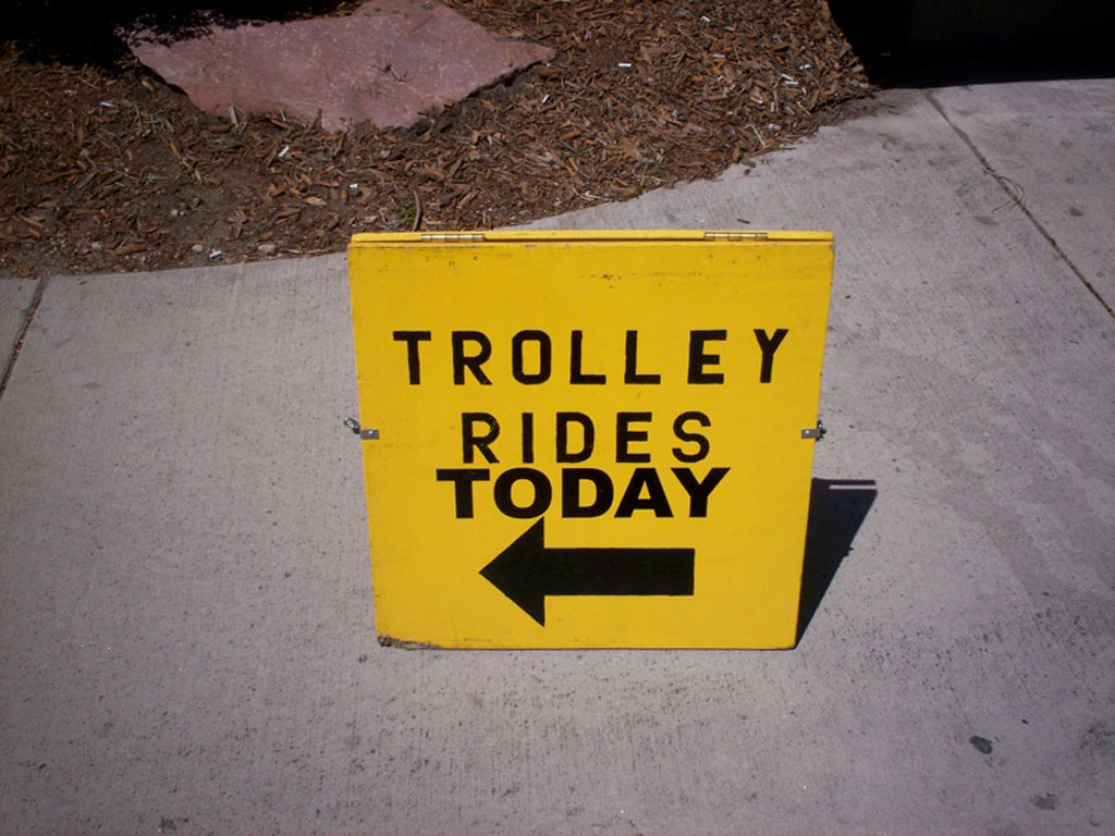 A cheerful yellow sign announces “Trolley Rides Today.” Credit: Paul Swansen, Flickr