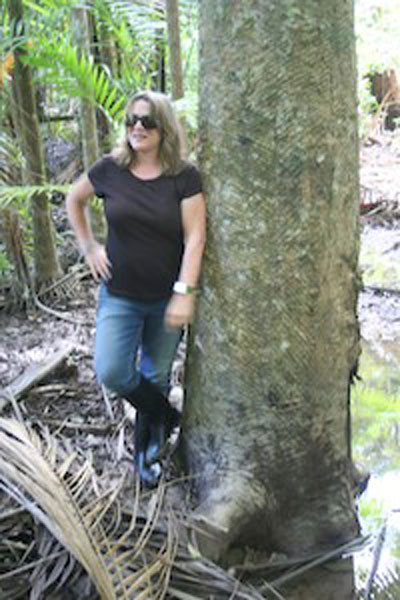 Photo of Susanna Hecht standing next to a large tree during her field work