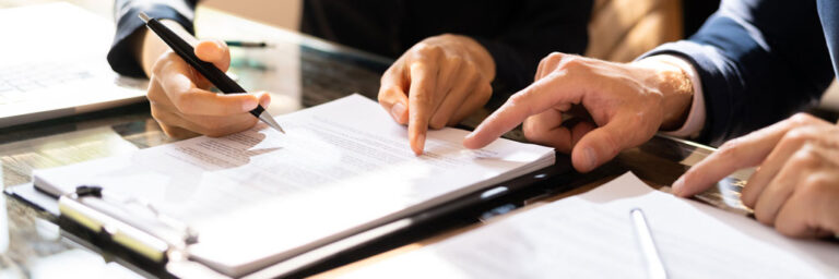 Photo of people discussing bylaws changes with focus on hands pointing at documents