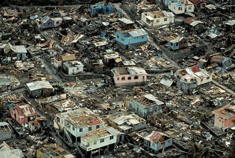 Aerial view of homes and businesses damaged by a tropical cyclone.