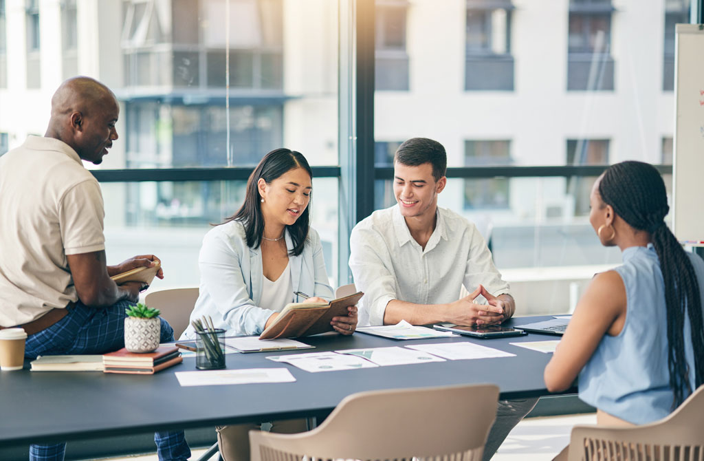 Reviewers sitting around office table and collaborating in a discussion.