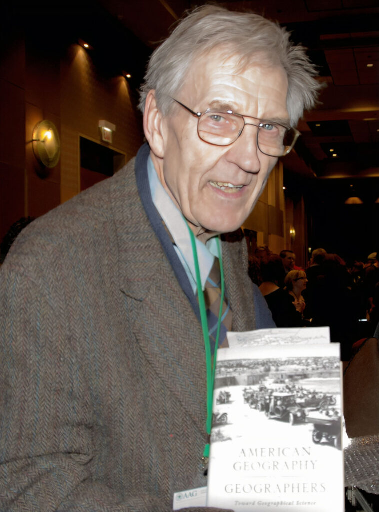 Geoffrey Martin shows a brand-new copy of his book, American Geography and Geographers: Toward Geographical Science, during the international reception at the 2015 AAG annual meeting held in Chicago.