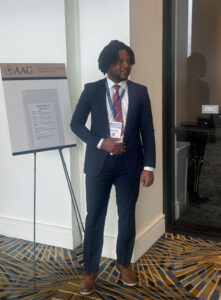 Michaelmary Chukwu poses next to a session board outside of a session room.
