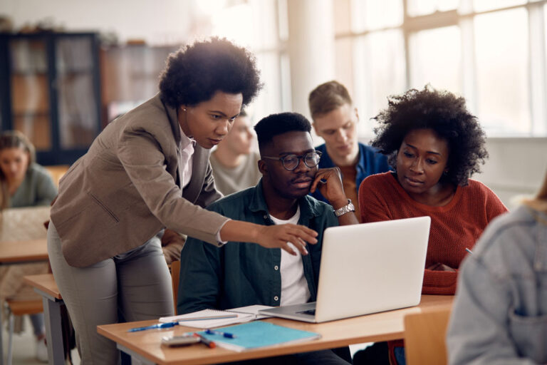 Several faculty convene around a laptop screen