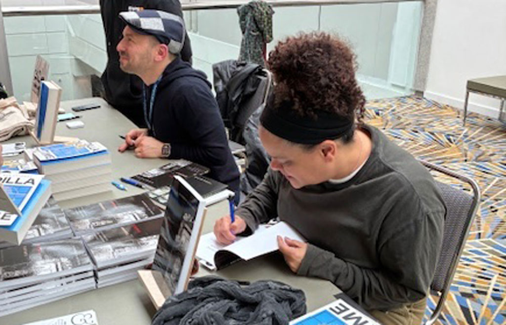 Geographer Katherine McKittrick and colleague Dan Charna participate in a joint book-signing at AAG 2025 in Detroit. Credit: Lisa Schamess, AAG