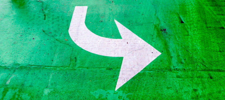 White curved arrow painted on green background (decorative); Credit: Donald Giannatti zHPTMNZz-NM, Unsplash