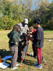 George Mason University GGS students gather data with a transit device to create contour maps of a local park in GGS as part of their Field Mapping class.