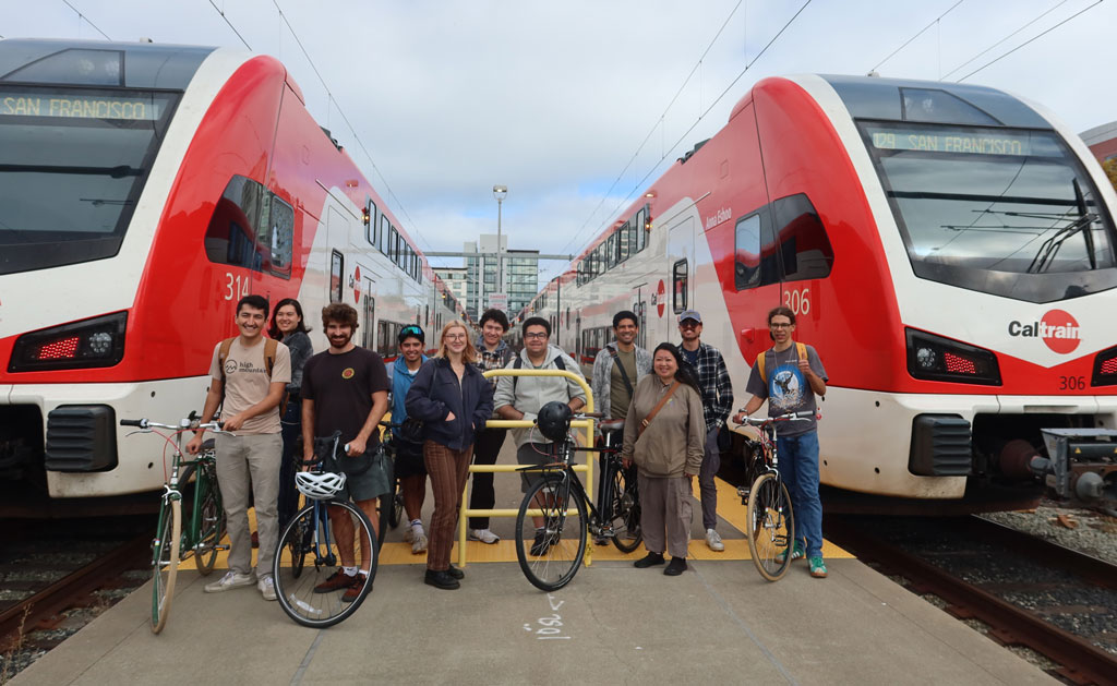 San Francisco State University students gather between two CalTrains for a transportation class field trip.