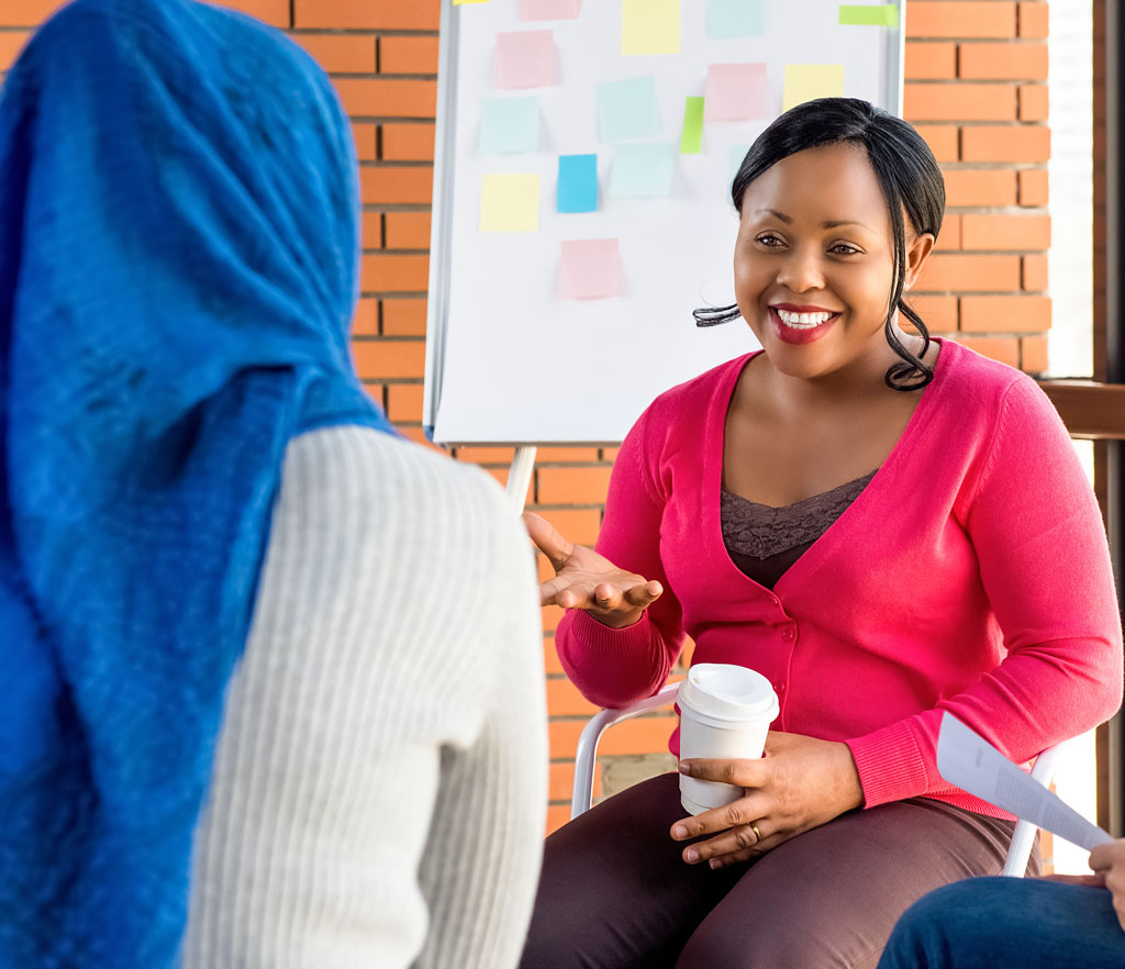 Diverse group of women in colorful clothes discuss a project