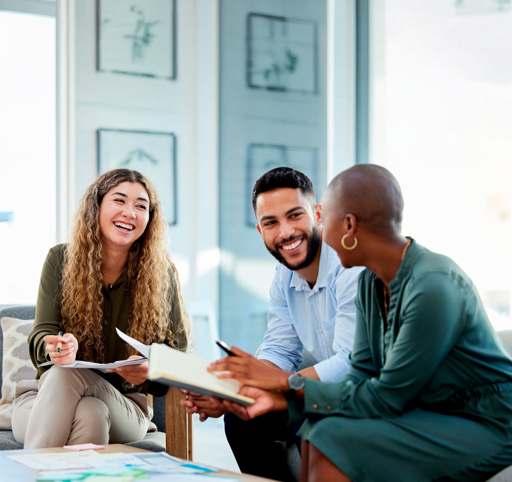 Diverse group of two women and one man discuss a project