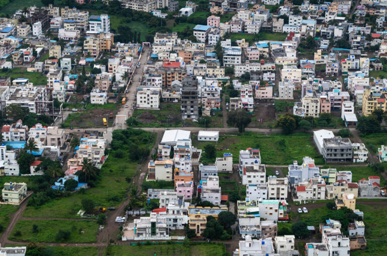 Large number of houses built on a hill with greenspace saved within.