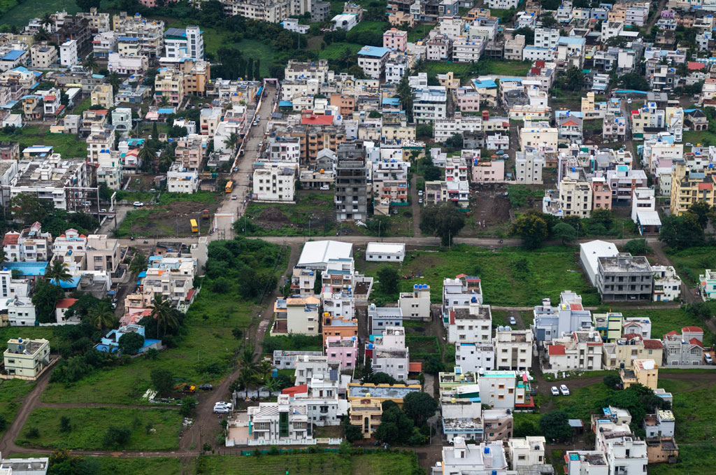Large number of houses built on a hill with greenspace saved within.
