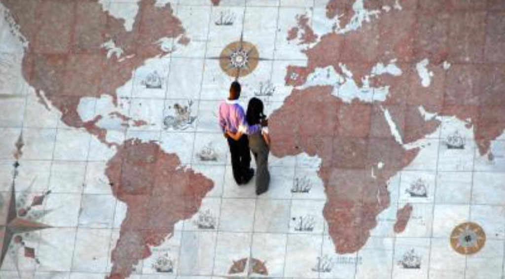 Black couple standing on giant world map on floor
