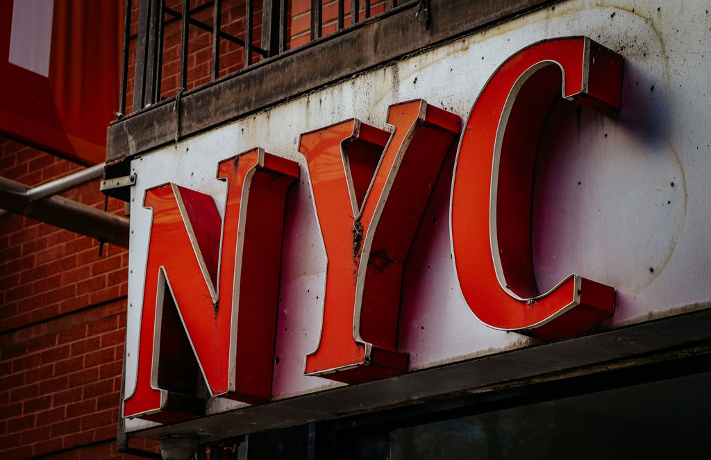 Close-up view of a New York City lighted sign with red letters NYC